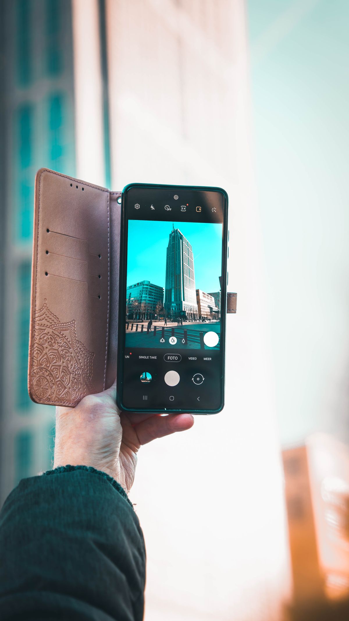 Personne photographiant une scène urbaine avec un smartphone.